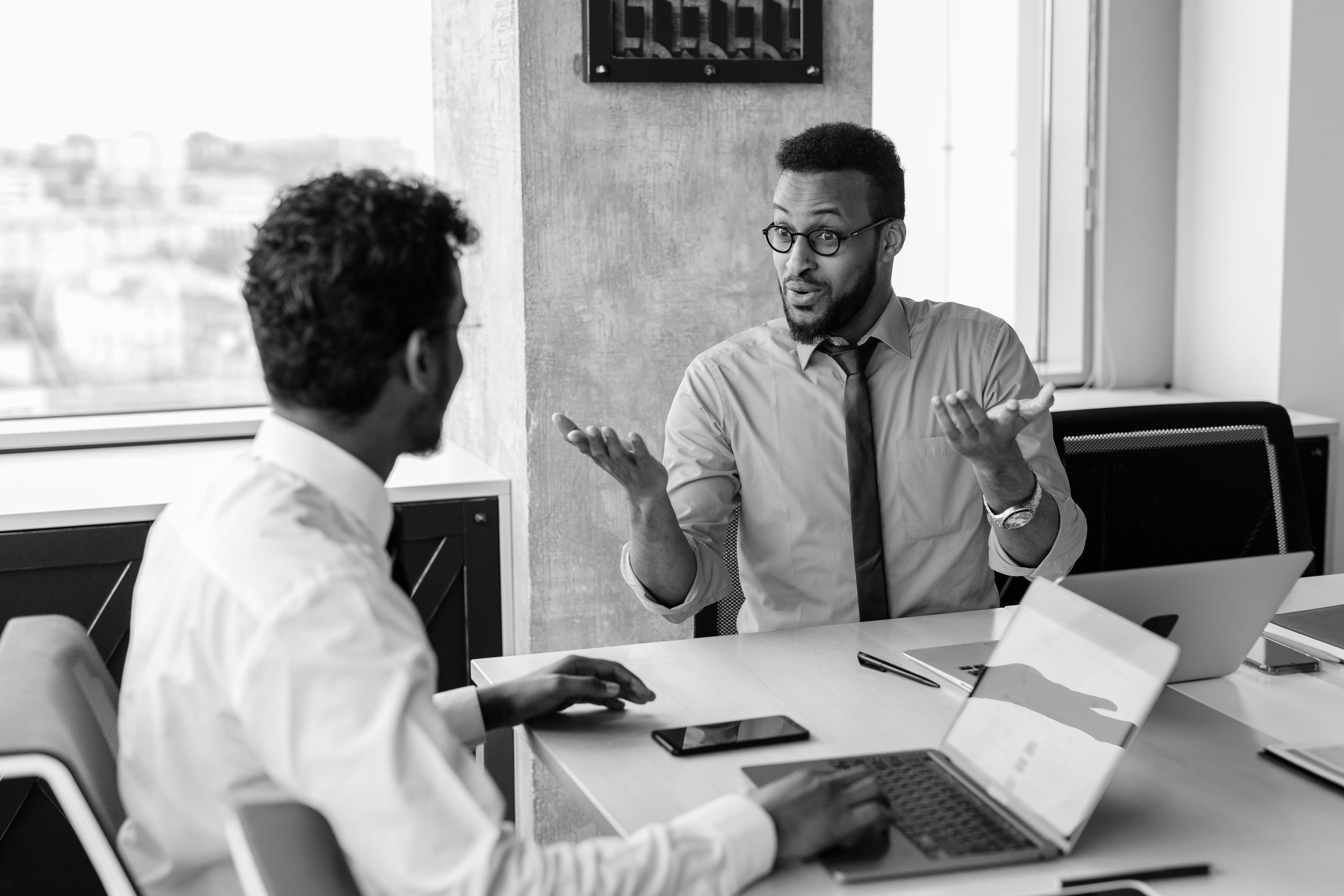 Two colleagues in conversation at a meeting table