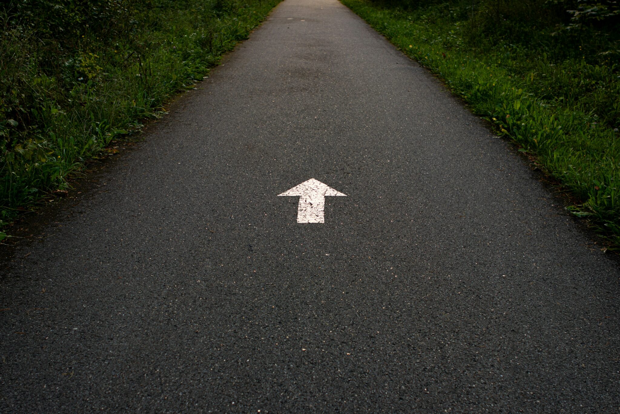 Arrow painted on a path pointing forward