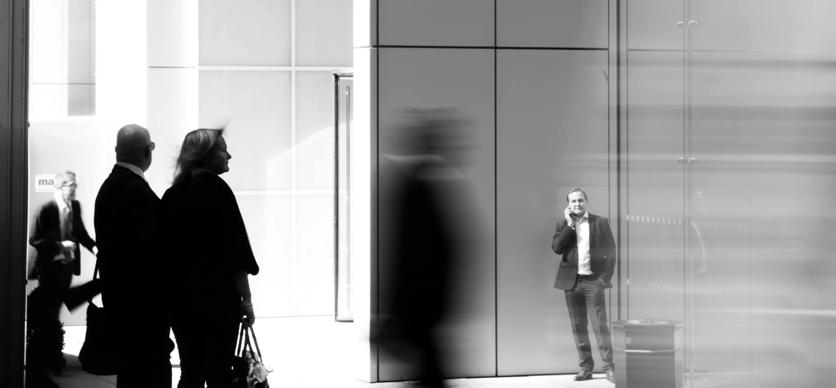 People silhouetted in a modern office foyer