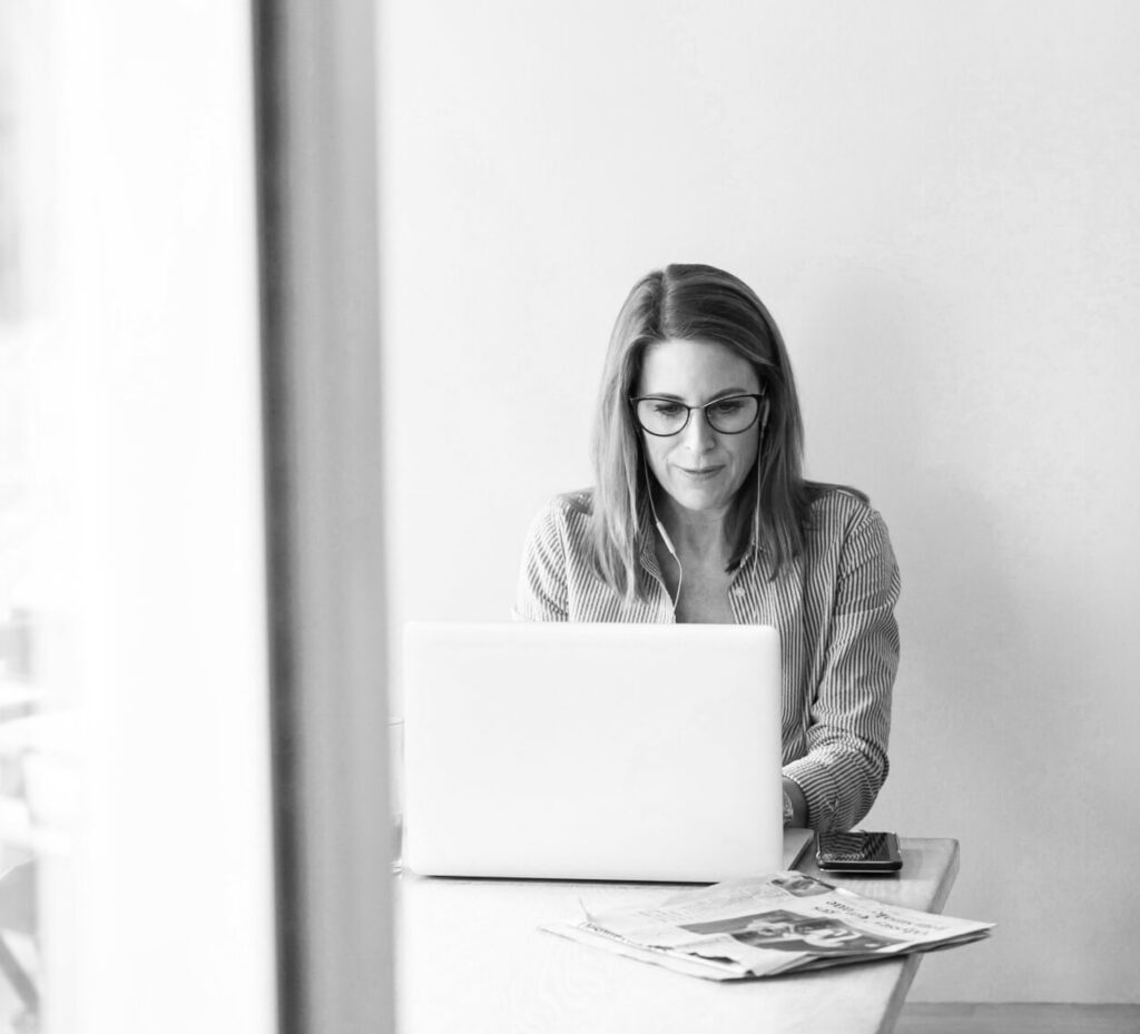 Woman working at a laptop by a window