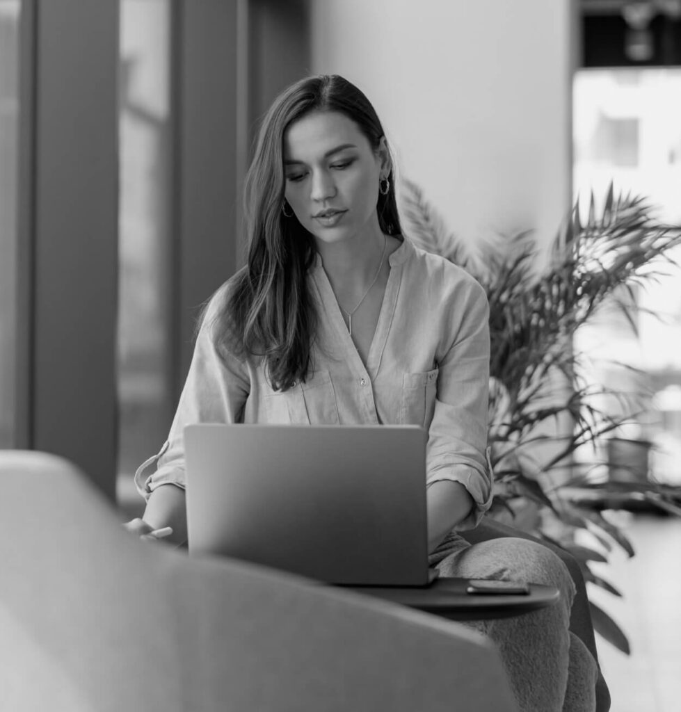 Woman working on a laptop in an office lounge