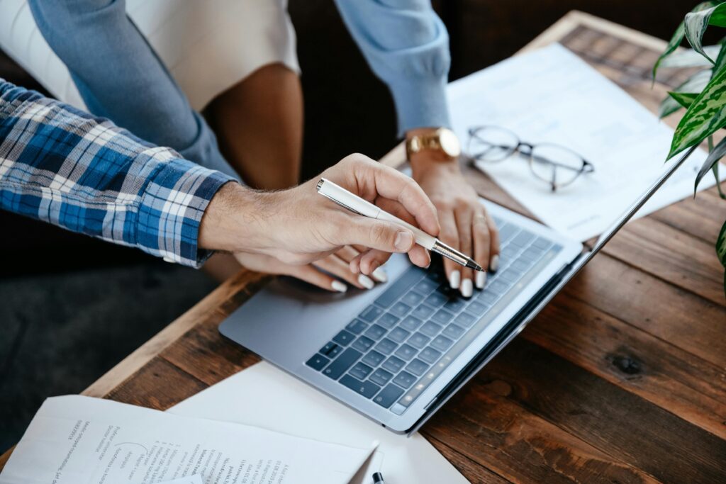 Person reviewing documents and working on a laptop