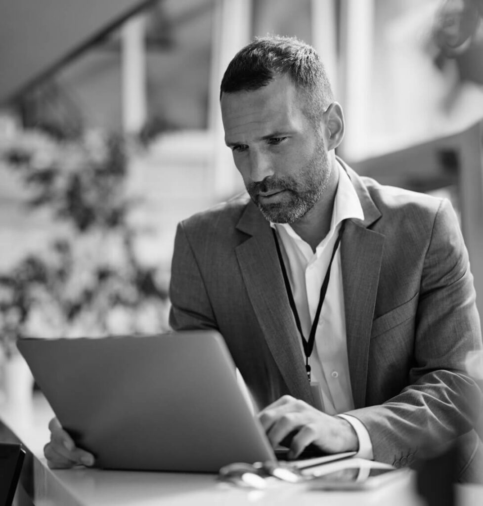 Professional in a suit working on a laptop