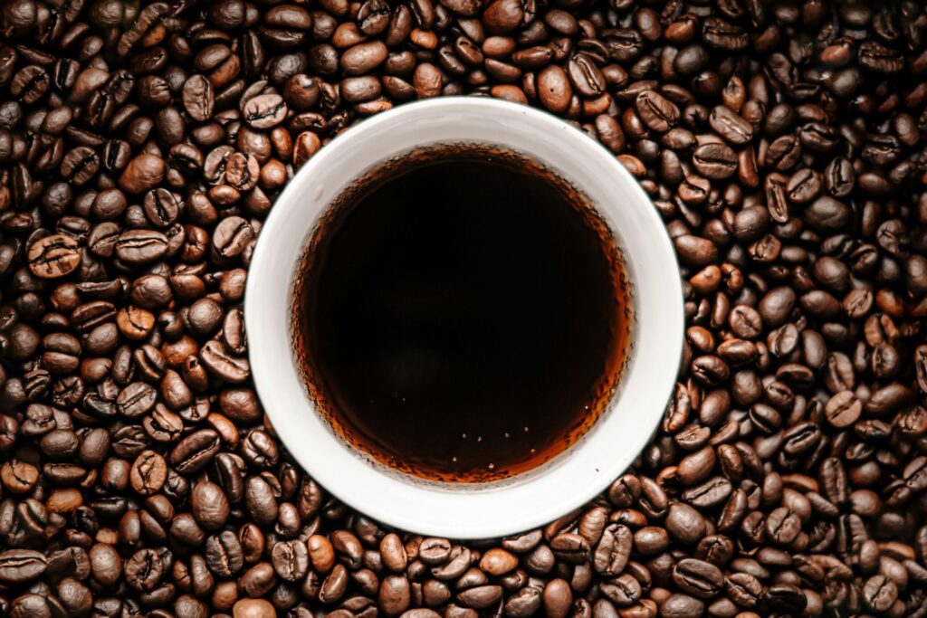 Cup of black coffee on a bed of coffee beans